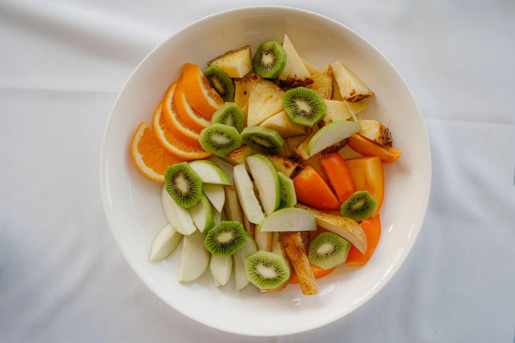 Miska z plasterkami kiwi pomarańczy i jabłka